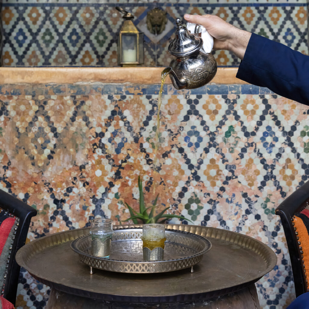 Moroccan serving mint tea in the traditional way